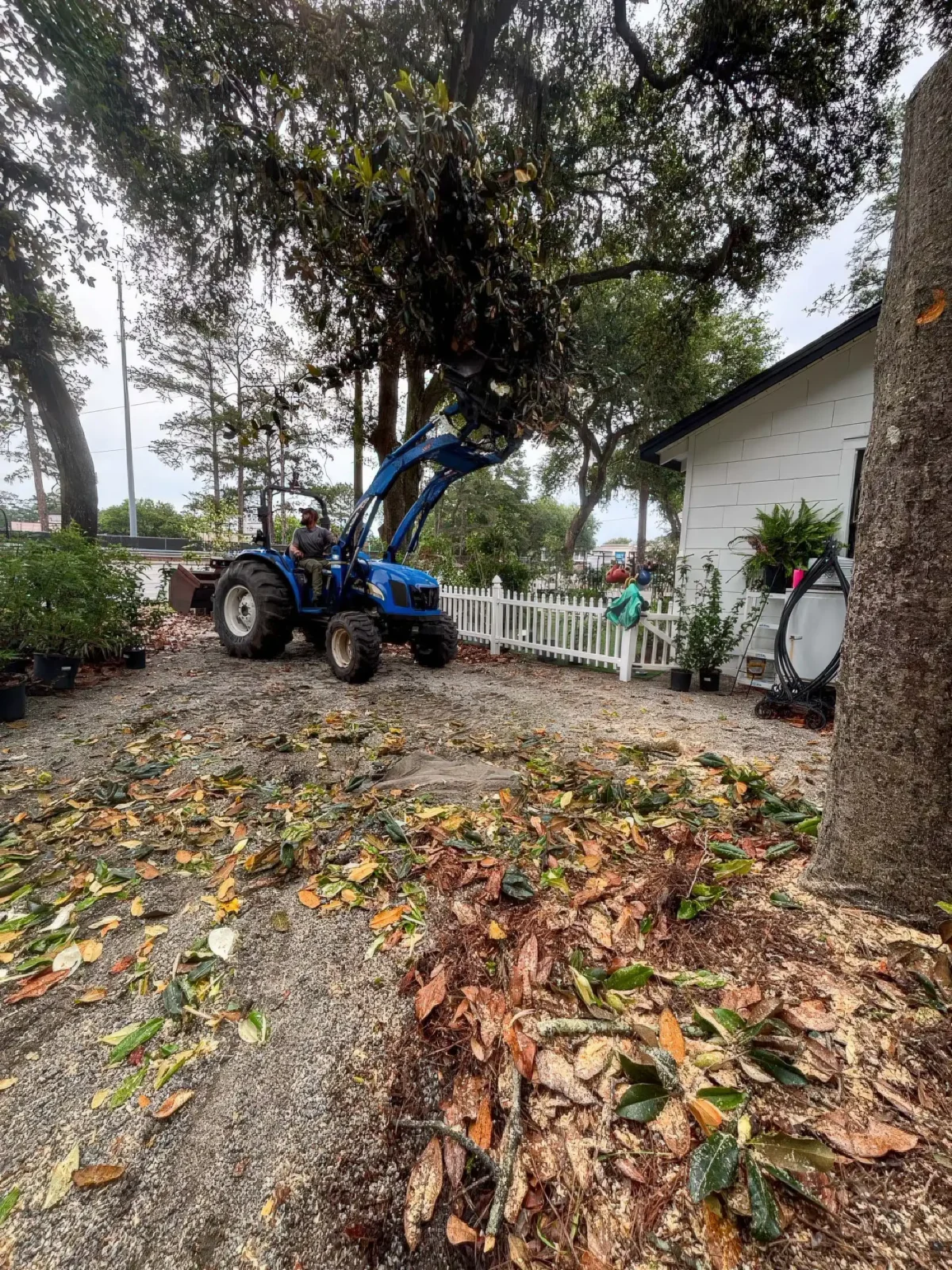 LoyalTree owner Michael Williams using a tractor to move a large log during cleanup
